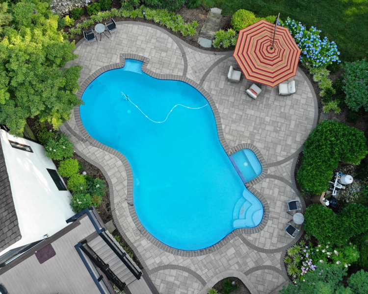 Overhead of pool with seating under umbrella in a home's backyard -Burkholder Landscape