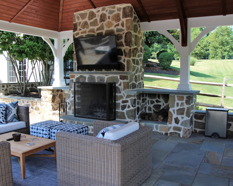 Structure: Pavilion with fireplace, TV, and wicker furniture - Burkholder Landscape