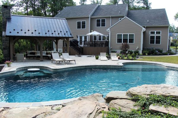 Backyard Oasis with pool, rock waterfall, pavilion and deck  | After Picture of ew Landscaping Project In Malvern | Burkholder Landscape