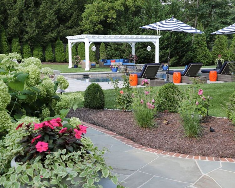 Landscaping: Shade loving Hydrangea, Ornamental Grasses and evergreen Boxwoods around flagstone patio