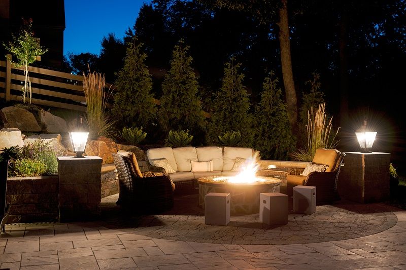 Firepit in landscape at night | fall lawn care tips | Burkholder Brothers