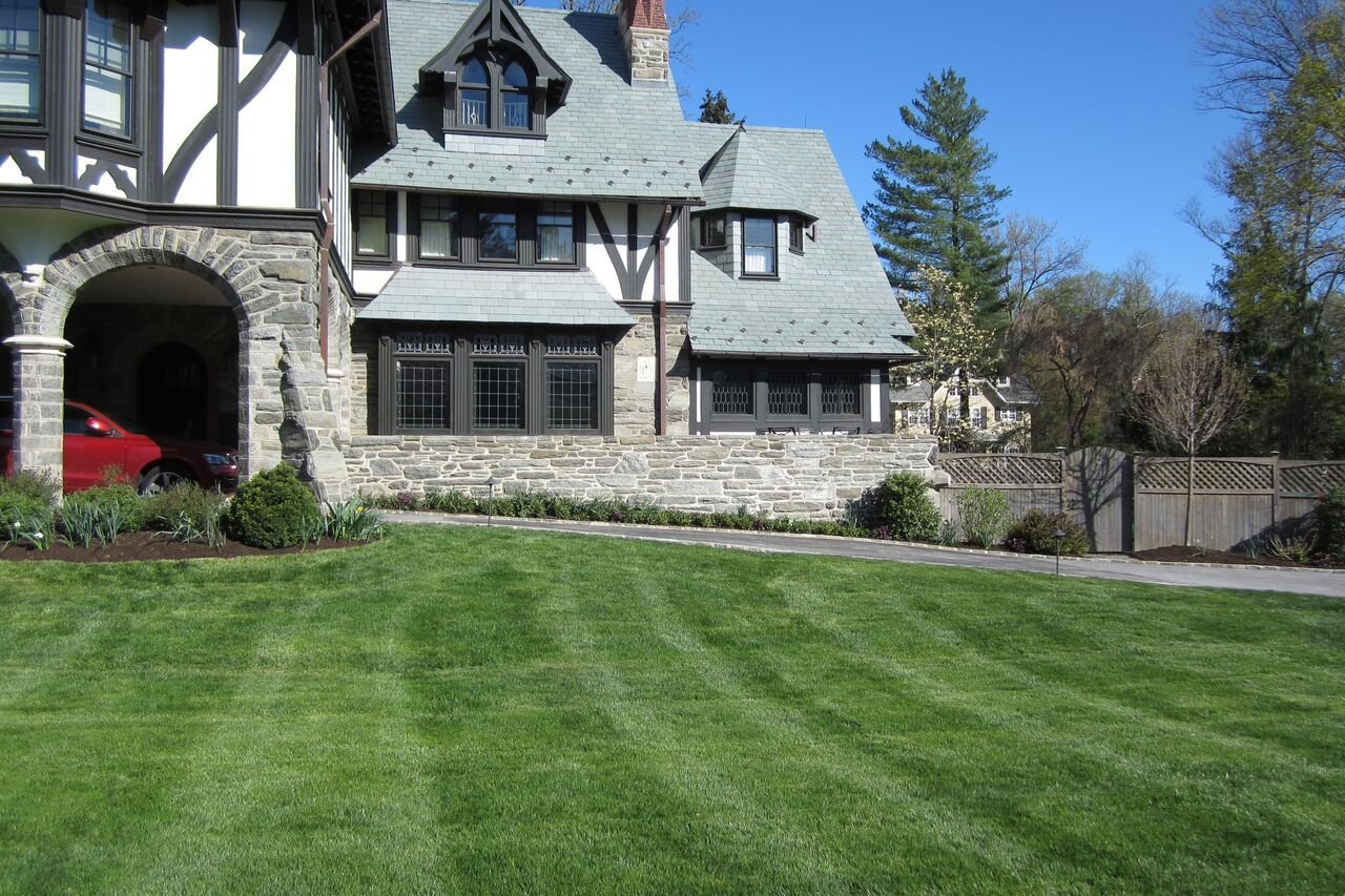 Home with green manicured front lawn | Lawn Renovations and Sod are often included in turf care programs | Burkholder Landscape 