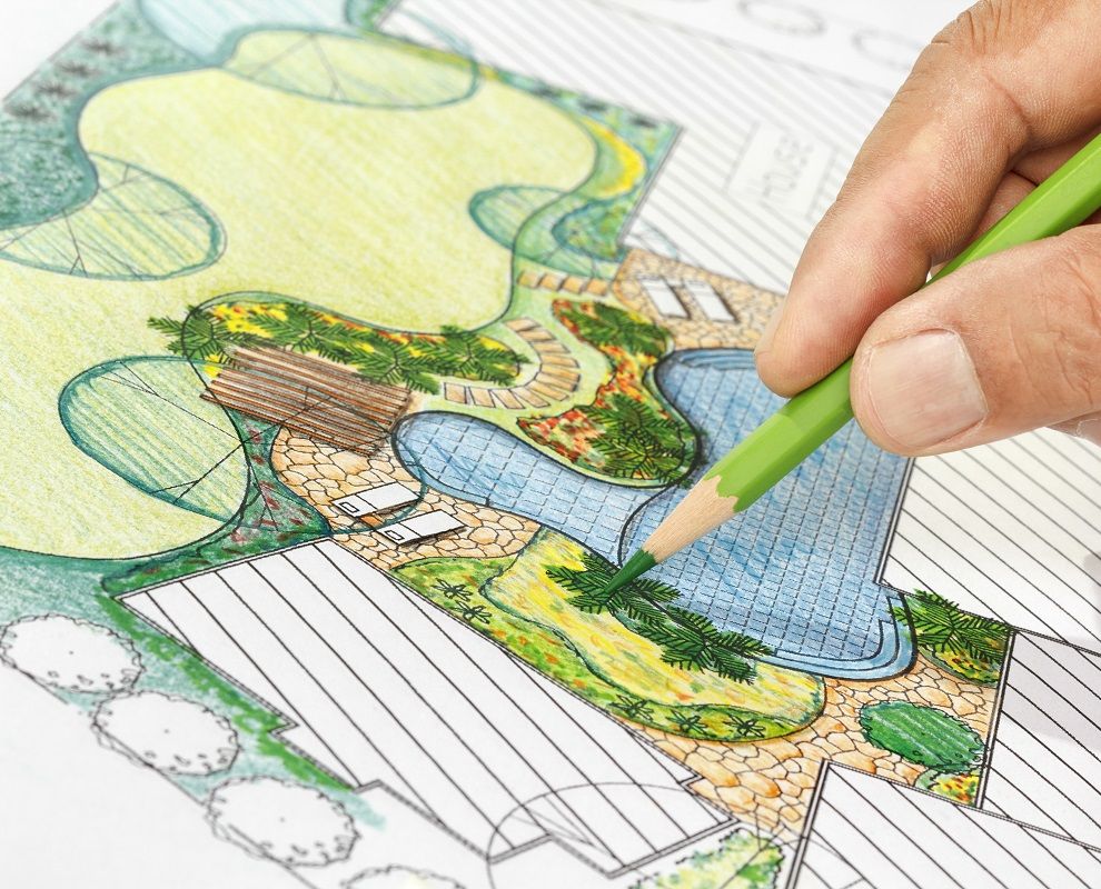 Hand with green pencil drawing a landscape design | Burkholder's Landscape Design Process