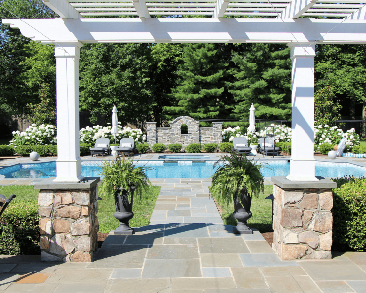 White pergola and walkway leading to pool area- Burkholder Landscape