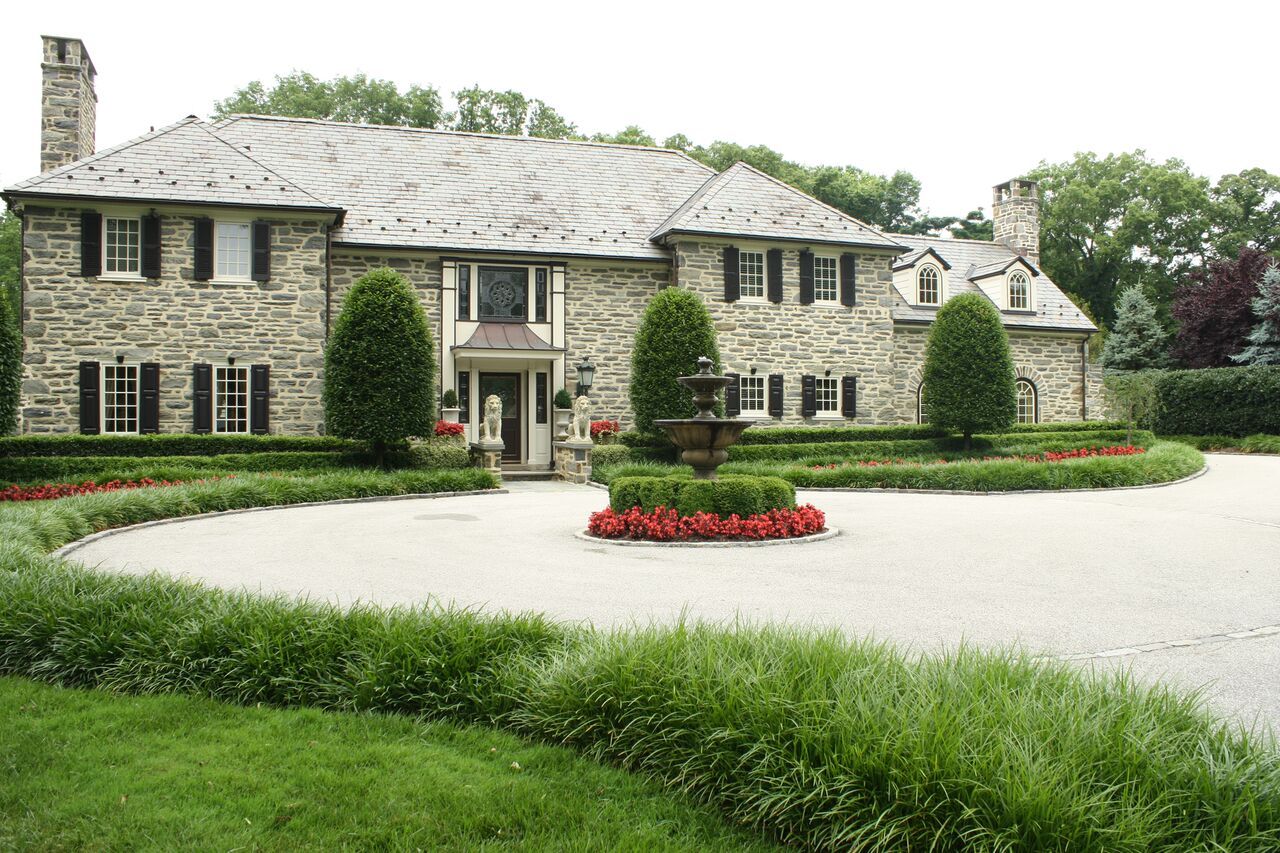 Front view of Large brick estate with circle drive and ornamental grasses - Estate Landscape Management - Burkholder Landscape