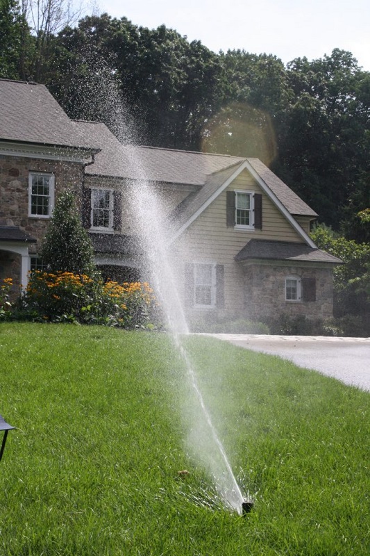 Sprinkler system running in front of house | Sir Sprinkler irrigation system | Burkholder Brothers