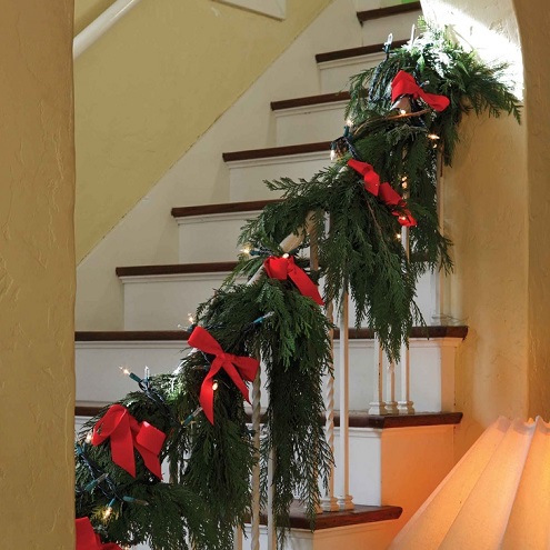 Evergreen garland and red ribbons on a stairway | Favorite Thanksgiving Traditions with Burkholder Landscape