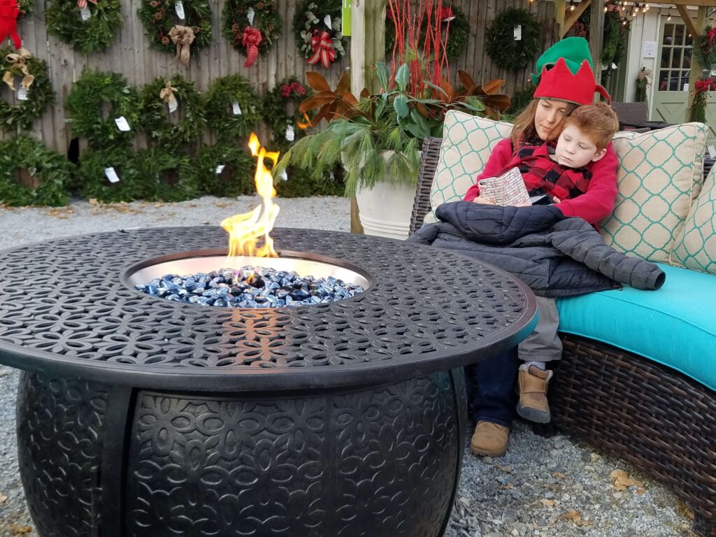 Woman and child sitting by a firepit | 2020 Holiday Market | Burkholder Brothers