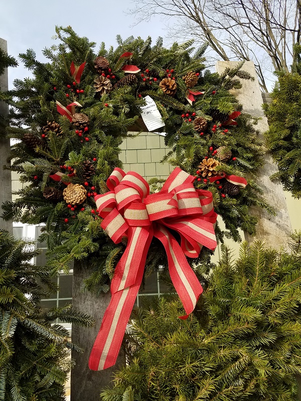 Wreath with pinecones berries and red with canvas ribbon at the Burkholder Holiday Pop Up Market